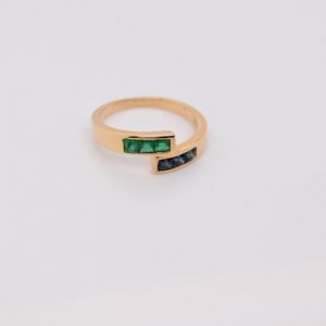 Minimalist 18K yellow gold ring adorned with square-cut natural emeralds and sapphires. Features 2x2 mm gemstones, with 3 emeralds and 3 sapphires. Size 5.75 US.