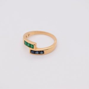 Minimalist 18K yellow gold ring adorned with square-cut natural emeralds and sapphires. Features 2x2 mm gemstones, with 3 emeralds and 3 sapphires. Size 5.75 US.