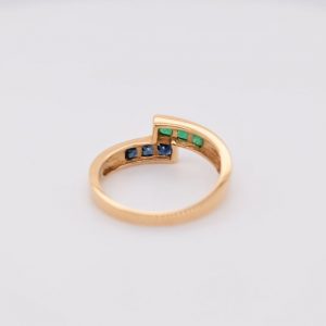 Minimalist 18K yellow gold ring adorned with square-cut natural emeralds and sapphires. Features 2x2 mm gemstones, with 3 emeralds and 3 sapphires. Size 5.75 US.