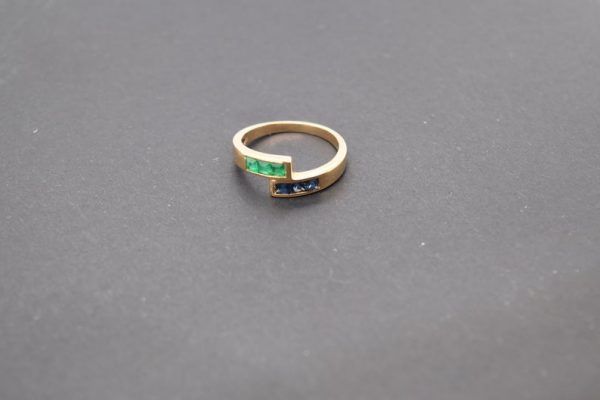 Minimalist 18K yellow gold ring adorned with square-cut natural emeralds and sapphires. Features 2x2 mm gemstones, with 3 emeralds and 3 sapphires. Size 5.75 US.