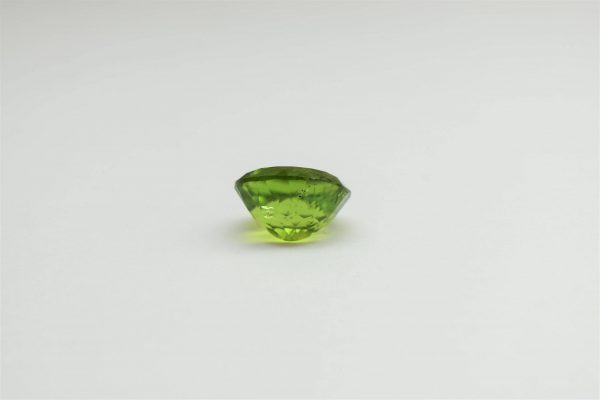 Natural peridot stone oval gemstone, 15.8x13.8x9.1 mm, 14.02 carats. August birthstone known for its positive energy and abundance.