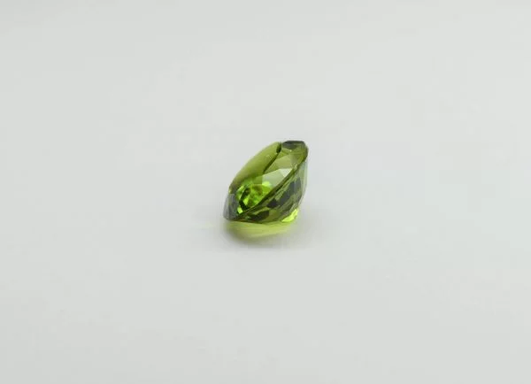 Natural peridot oval gemstone, 15.6x12.9x8.3 mm, 11.86 carats. August birthstone known for positive power and abundance