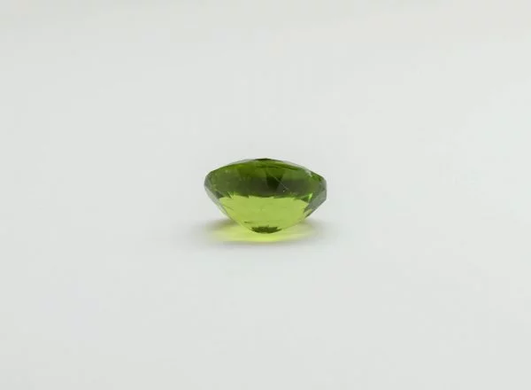 Natural peridot oval gemstone, 15.6x12.9x8.3 mm, 11.86 carats. August birthstone known for positive power and abundance