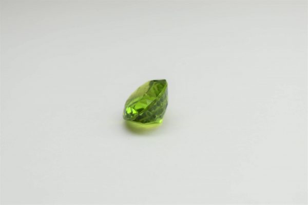 Natural peridot stone oval gemstone, 15.8x13.8x9.1 mm, 14.02 carats. August birthstone known for its positive energy and abundance.