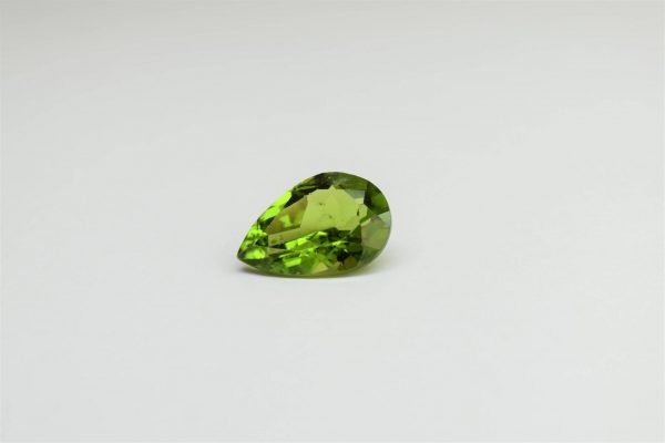 Natural peridot stone pear-shaped gemstone, 19x12.8x8.1 mm, 12.91 carats. August birthstone known for its positive energy and abundance.